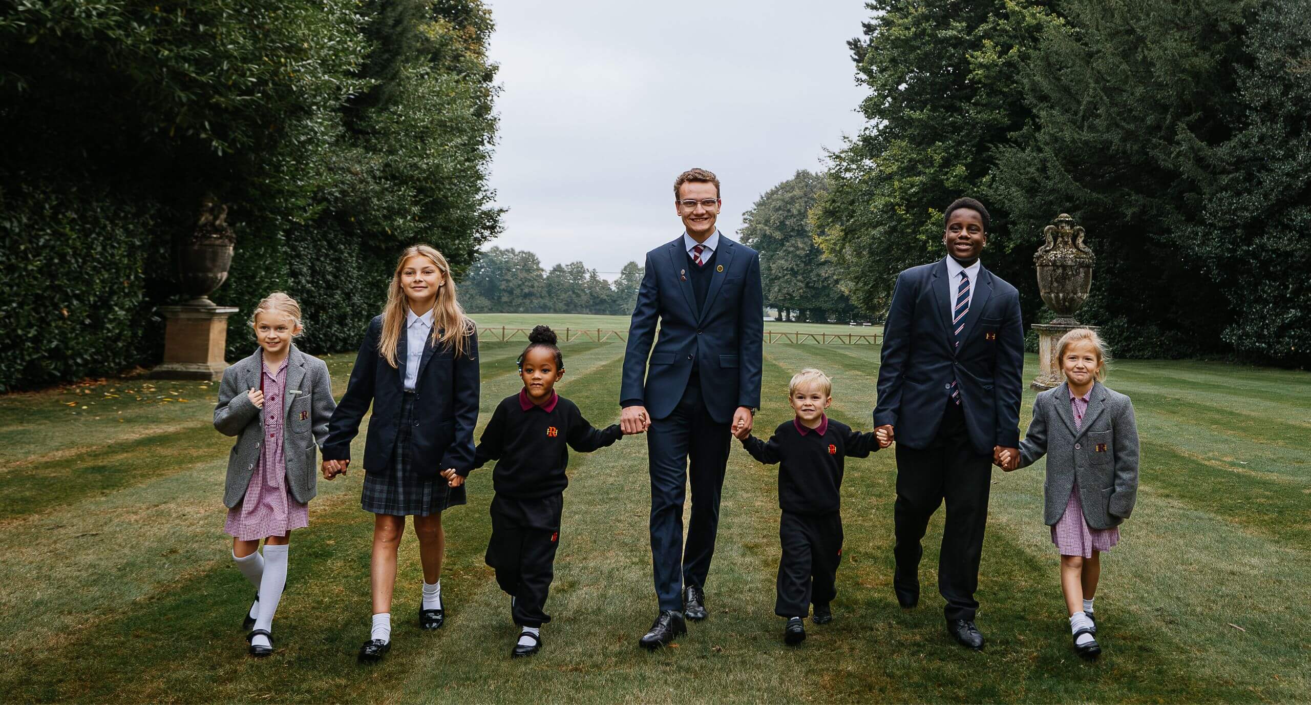 Students holding hands, walking across a field