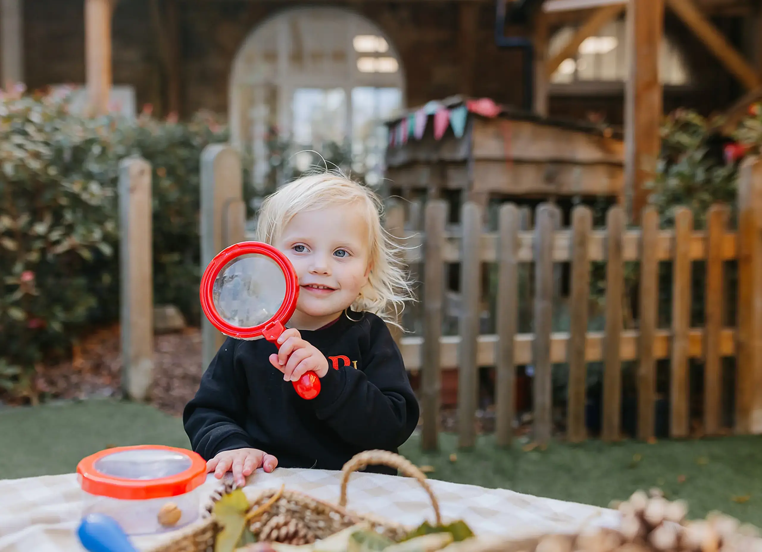 Early Years pupil with magnifying glass