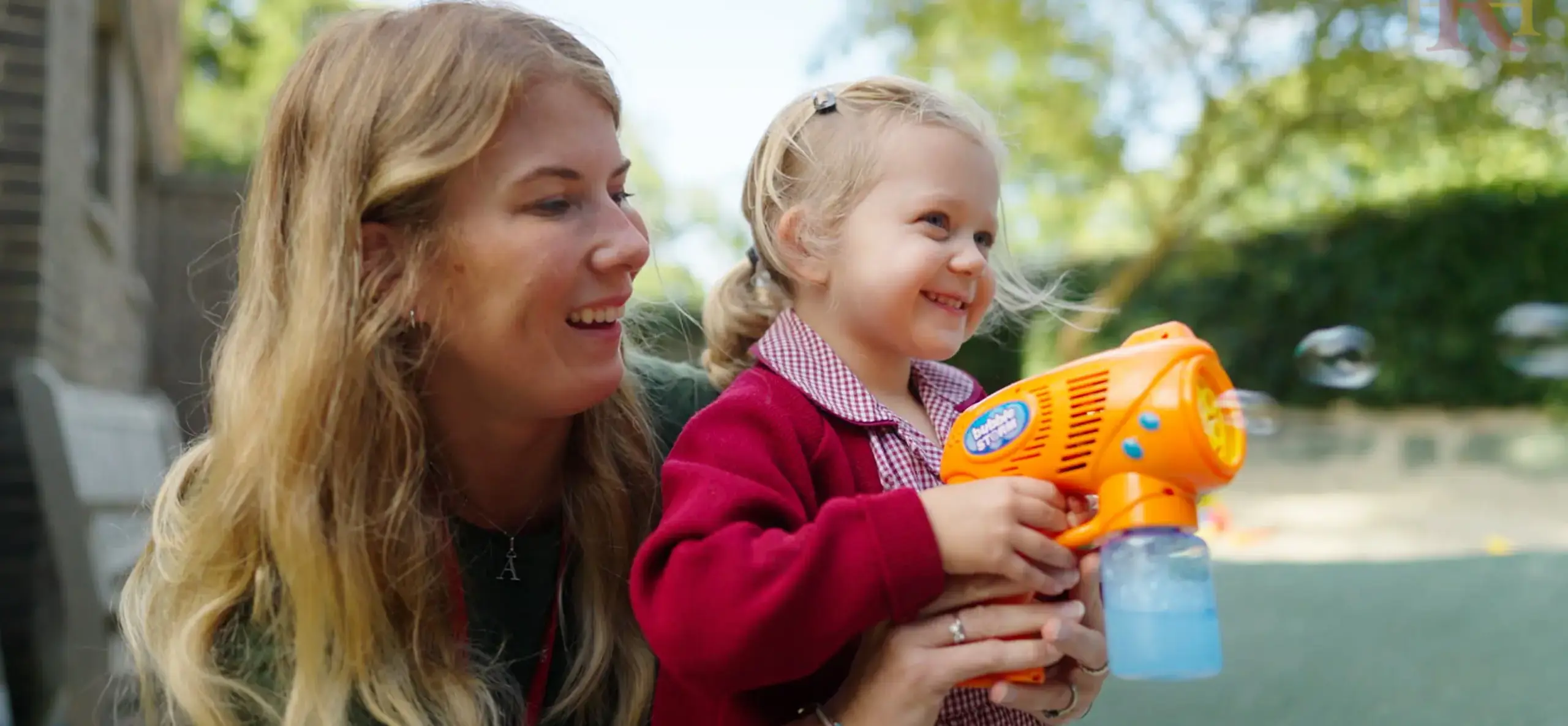 Teacher and student playing with a wtaer gun
