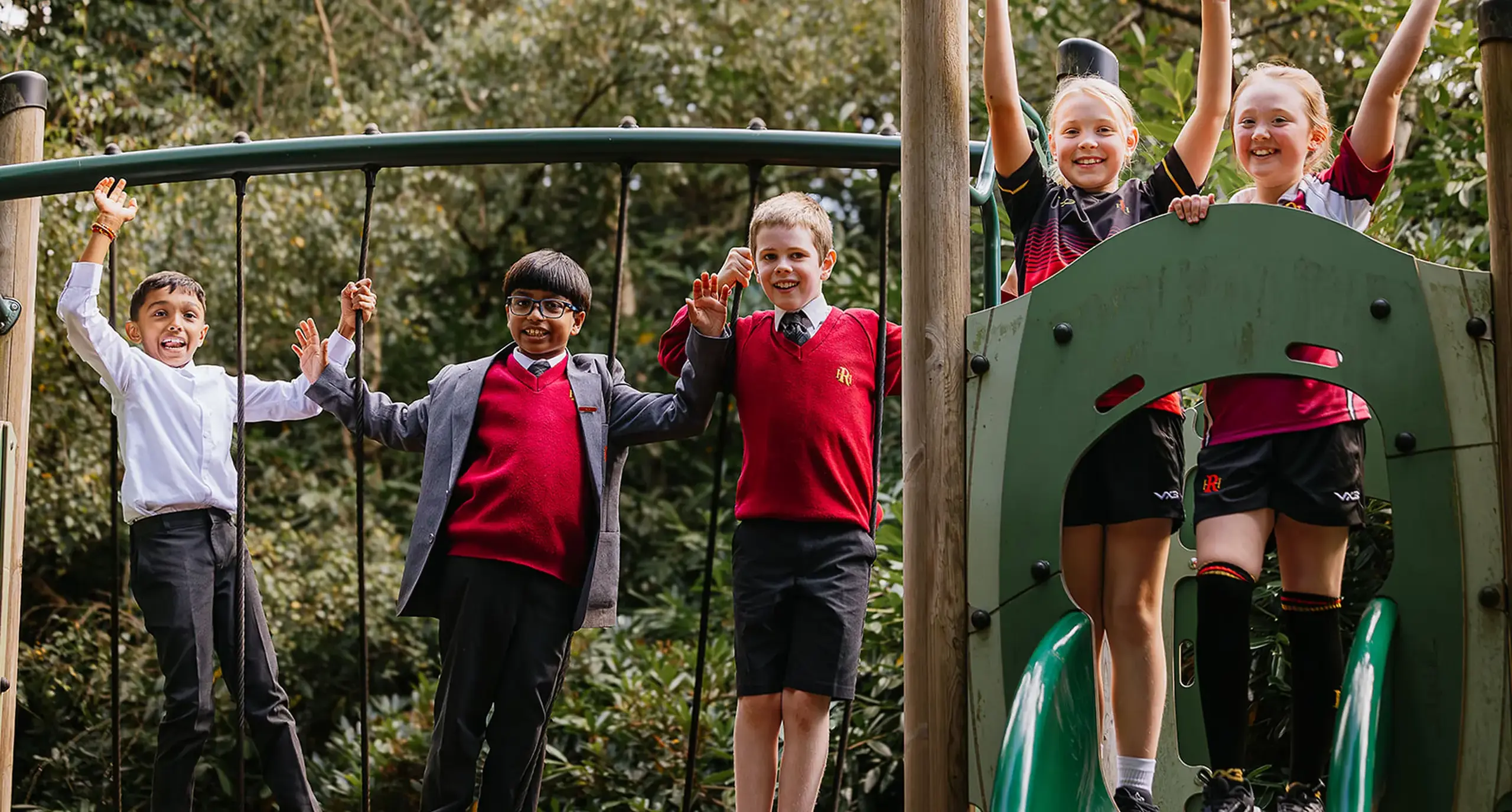 A group of prep school children smiling on a climbing frame