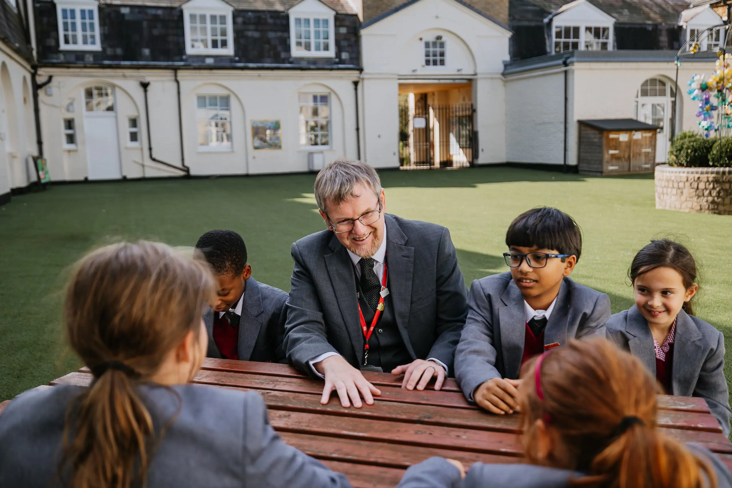 Radnor teacher sitting at picnic table with students