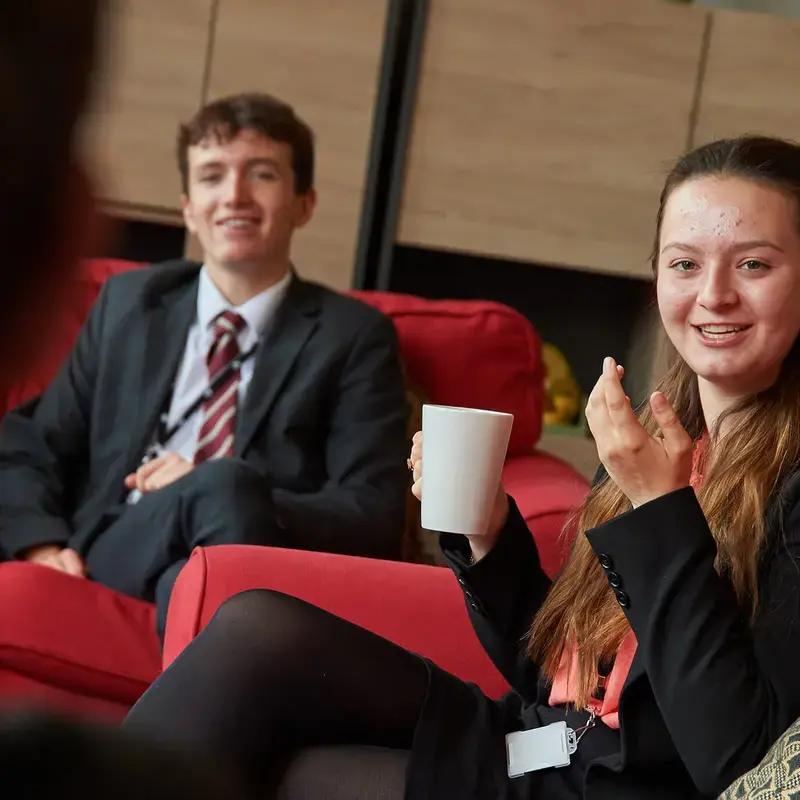 Radnor House Sevenoaks Sixth Form student talking to a student in the common room